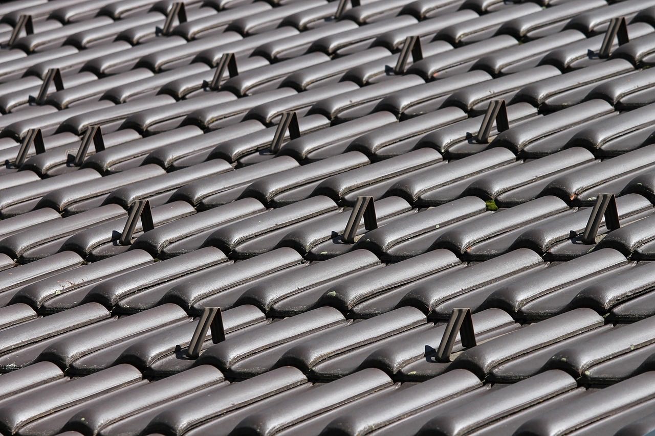 Close-up detail of roof flashing and ridge vent installation showing professional quality materials and precise fastening