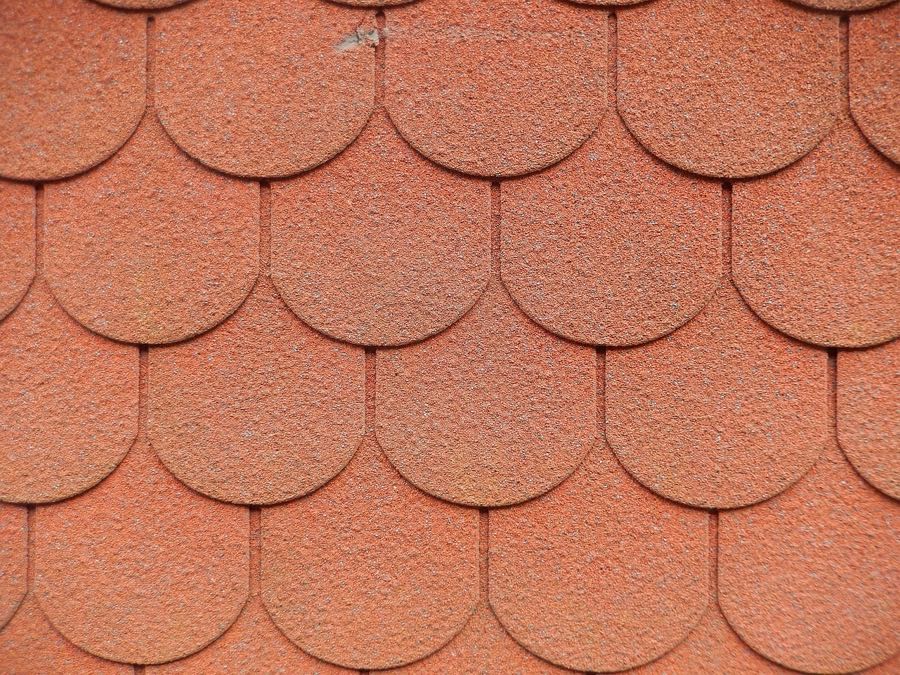 Architectural detail of traditional clay roof shingles with overlapping tiles and textured surface